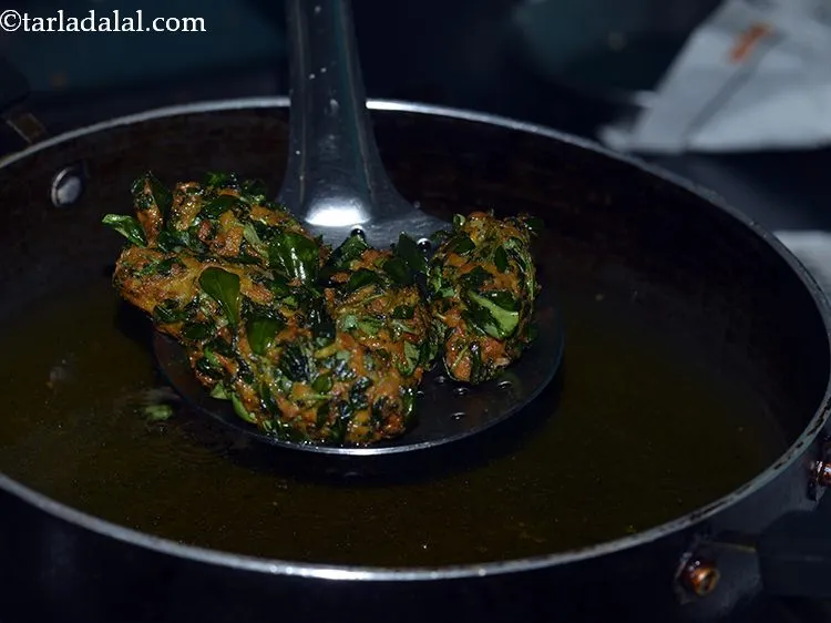 Step 23 – Deep-fry a few fenugreek muthiyas on a medium flame till they turn golden brown in …