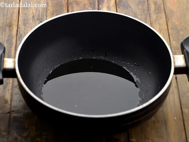Step 5 – For <strong>besan methi pitla</strong>, heat the oil in a deep non-stick kadhai.