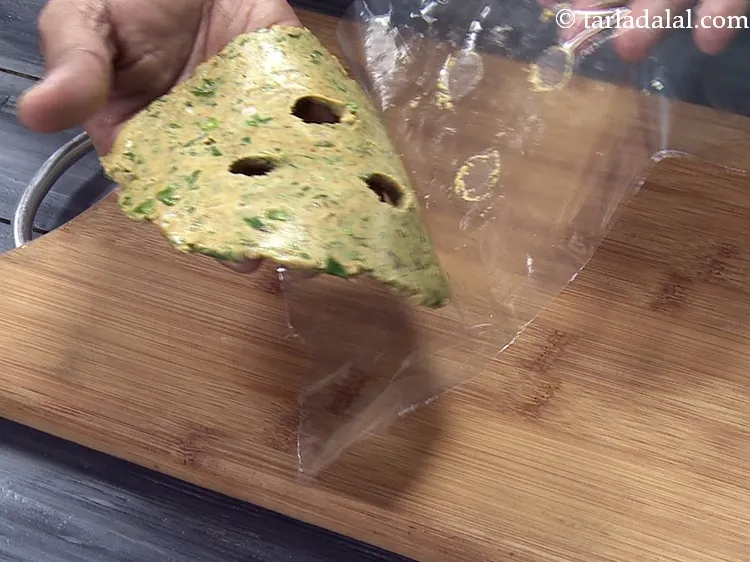 Step 40 – Lift the rolled thalipeeth by separating out the plastic.&nbsp;