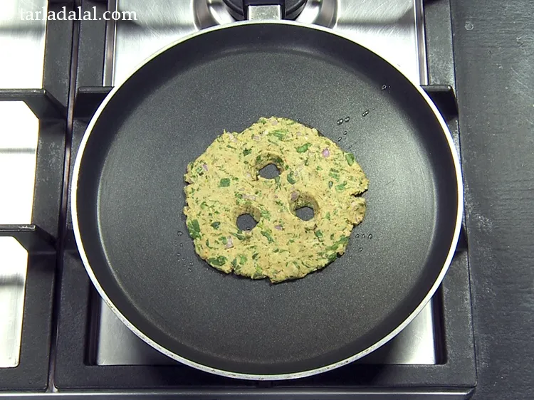 Step 41 – Place the thalipeeth on the hot tava.&nbsp;