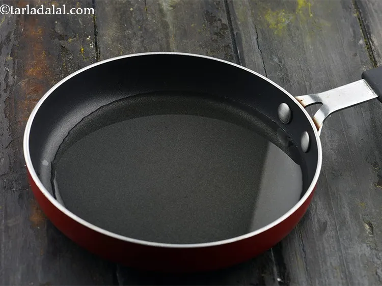 Step 2 – To prepare homemade <strong>Gujarati koro sambar masala</strong>, heat the oil in a broad non-stick pan …