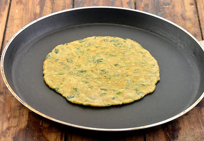 Step 23 – Heat a non-stick tava (griddle) and cook the <strong>Methi Thepla</strong>, on a medium flame.
