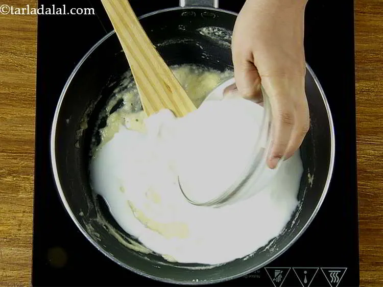 स्टेप 4 – अब, दूध डालें। मिश्रण को लगातार चलाते रहना बहुत जरूरी …