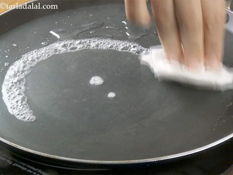 Step 14 – Wipe off using a piece of cloth. When you pour the batter, the tava should …