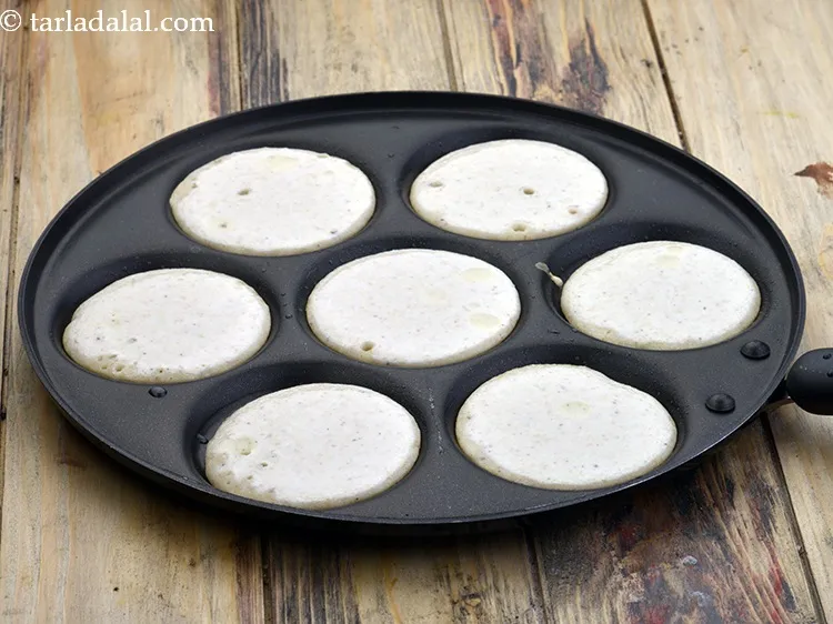 स्टेप 35 – प्रत्येक उत्तपम सांचे में छोटे चम्मच से घोल डालकर 75 …