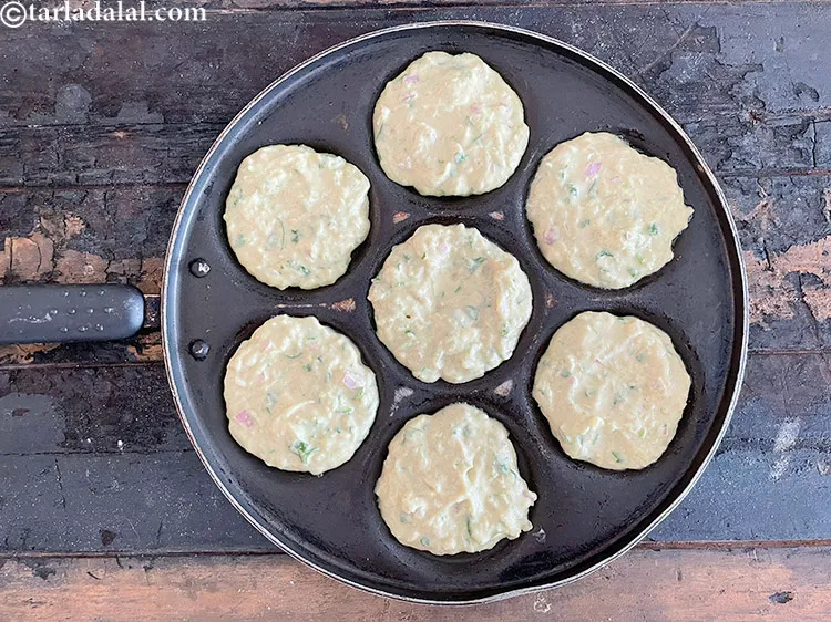 Step 24 – Pour 2 tbsp of the batter in each of the uttapa moulds and spread it …