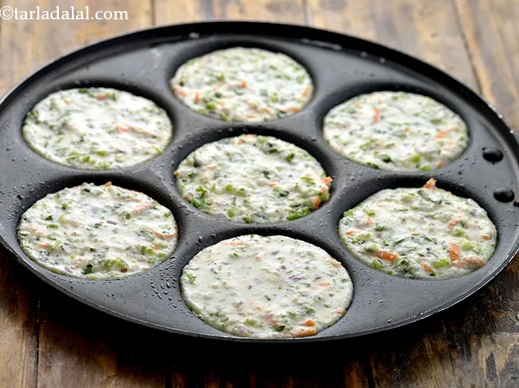 स्टेप 13 – प्रत्येक उत्तपम मोल्ड में एक चम्मच घोल डालें और ७५ …