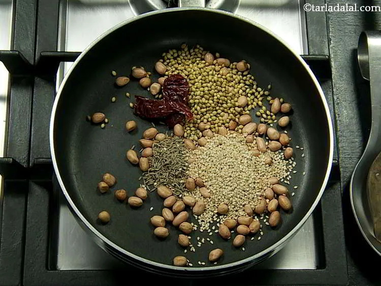 Step 10 – Break the dry red Kashmiri chilli into pieces and add them to the pan.