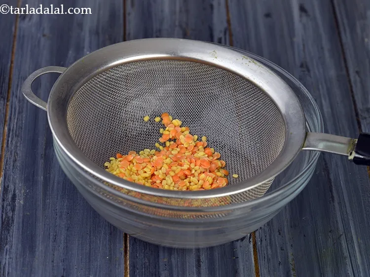 Step 8 – Drain the excess water using a strainer and discard it. Keep the dals aside.<span style="font-family: …