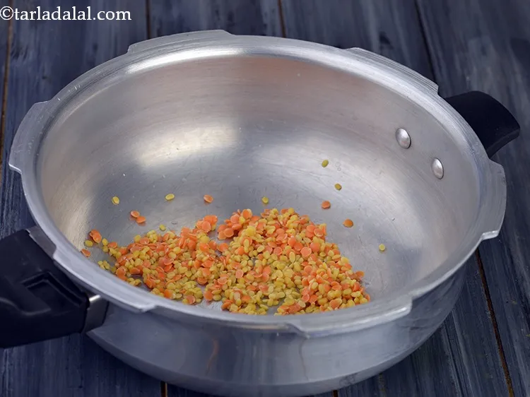 Step 19 – Now transfer the washed yellow moong dal and masoor dal into a clean pressure cooker.&nbsp;&nbsp;