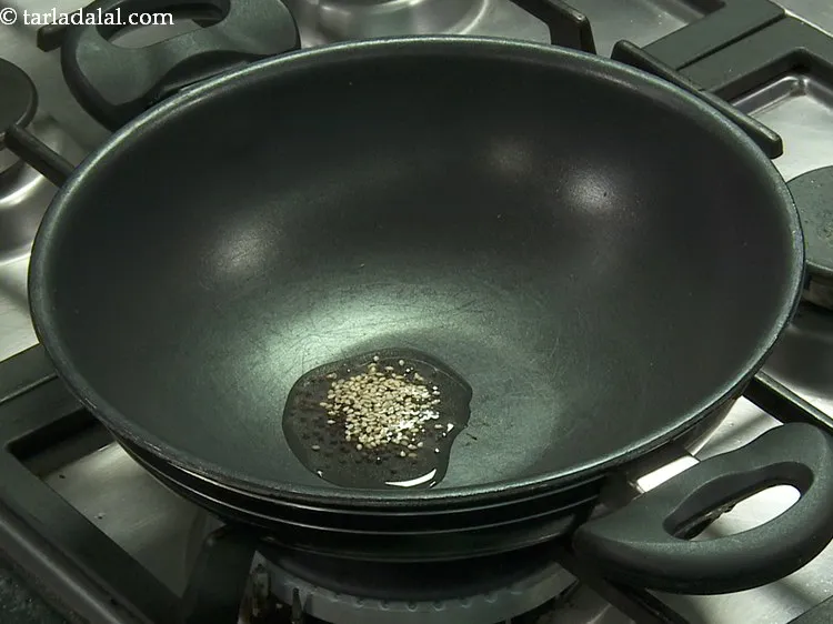 Step 25 – Add the sesame seeds. They provide a nice crunchy mouthfeel to the <strong>Handvo</strong>.