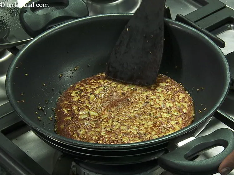 Step 30 – Lift the <strong>handvo</strong> gently using a large flat spoon and turn it over gently to …