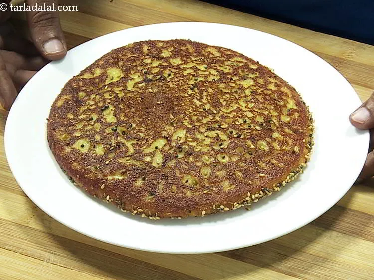 Step 32 – To prepare <strong>Gujarati mixed dal Handvo</strong> recipe in a pan, heat the remaining 1 tsp …