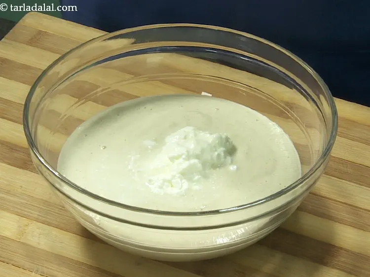 Step 10 – Add sour curd. It imparts a nice flavour to the easy <strong>Gujarati handvo</strong> recipe.