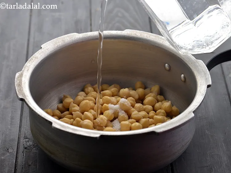 Step 3 – Transfer the soaked chana to a pressure cooker. Add the salt and ___ cup of …