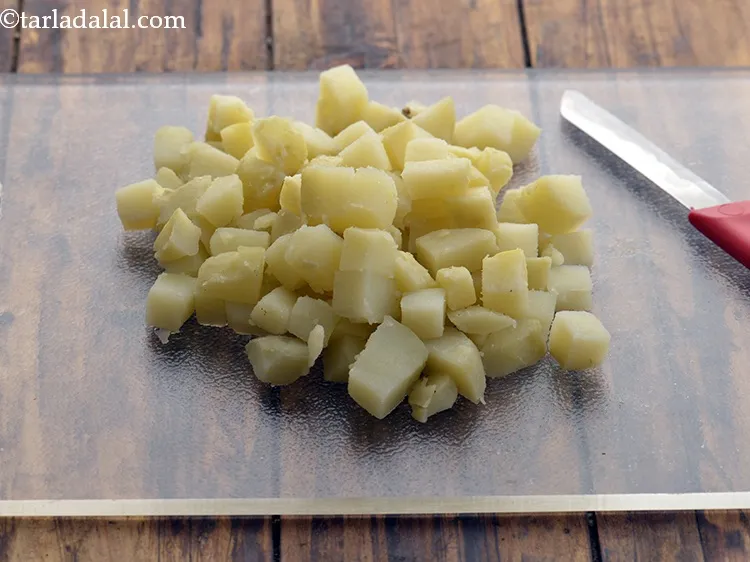 Step 23 – Cool completely and peel them. Discard the skin. Transfer the boiled potatoes to a chopping …