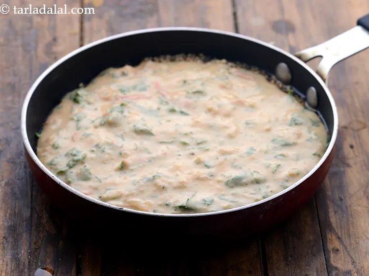 स्टेप 18 – तैयार हैंडवा घोल के एक हिस्से को डालें और समान …