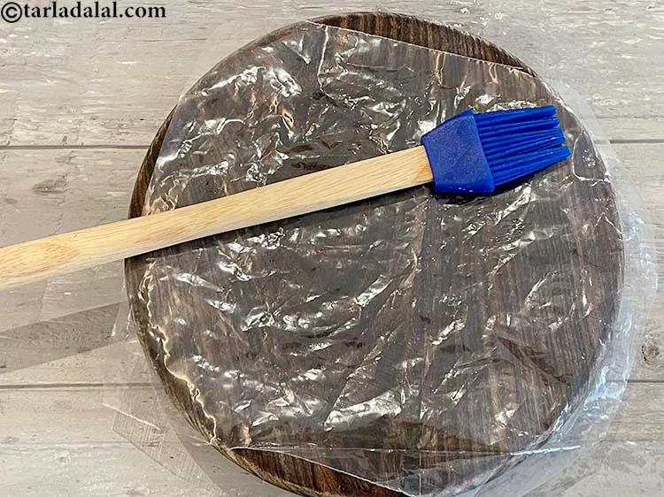 Step 13 – Using a brush, grease the plastic sheet with 1/4 tsp of oil. This makes rolling …