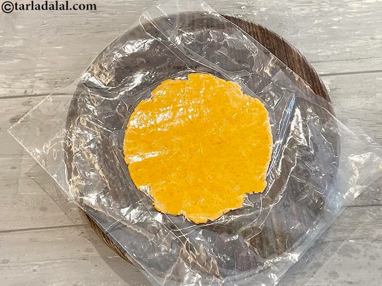 Step 18 – Keep rotating the plastic to make a circular dough while rolling. Since we have greased …