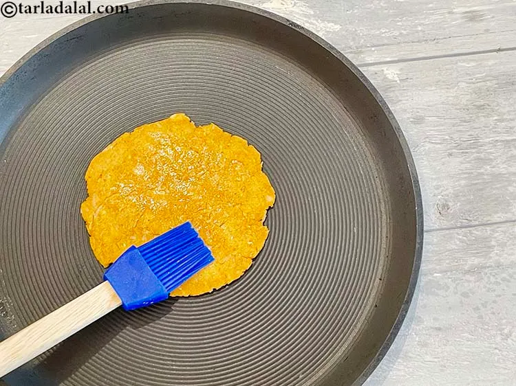 Step 24 – Add some oil (approximately 1/4 tsp) on top of the <strong>sorghum radish paratha</strong>.