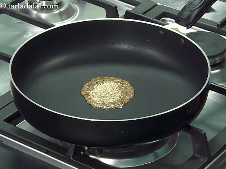 Step 22 – When the seeds crackle, add the sesame seeds.