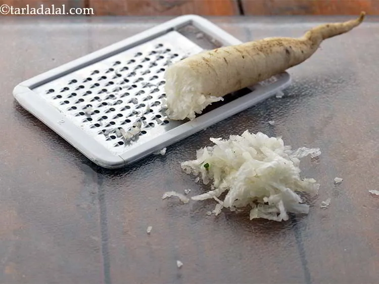 Step 2 – To prepare dough for mooli muthia, firstly peel and grate the mooli.