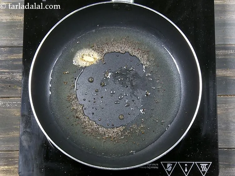 Step 8 – When the seeds crackle, add the asafoetida.