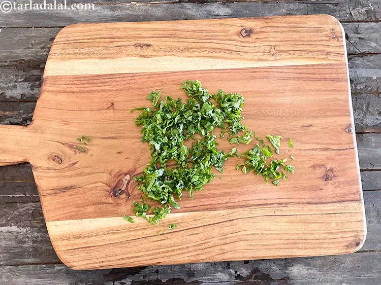 स्टेप 11 – मूली के पत्तों को चॉपिंग बोर्ड पर रखकर काट लें। …