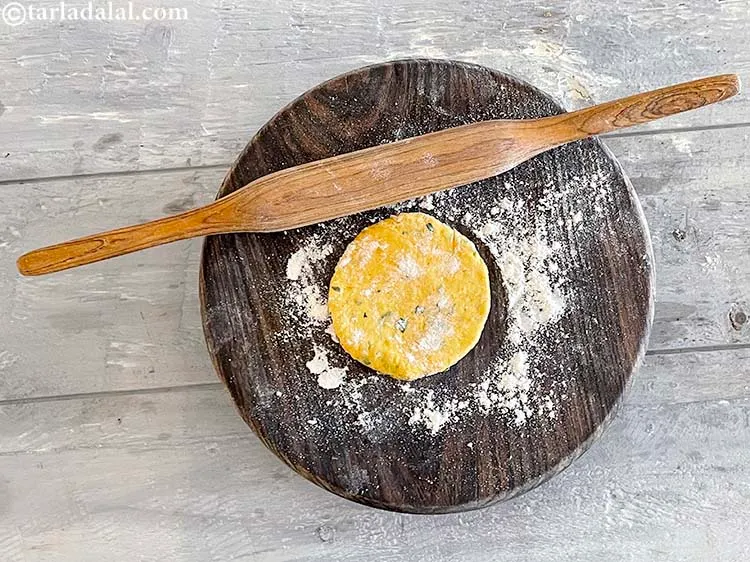 Step 25 – Softly flatten the dough ball with a belan (roller)