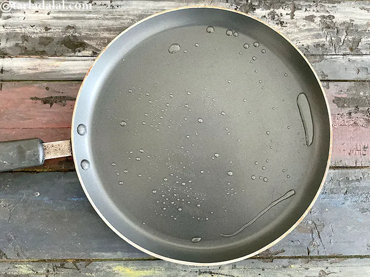 Step 26 – <meta charset="UTF-8" />Grease a non-stick tava (griddle) using &frac14; tsp of oil.