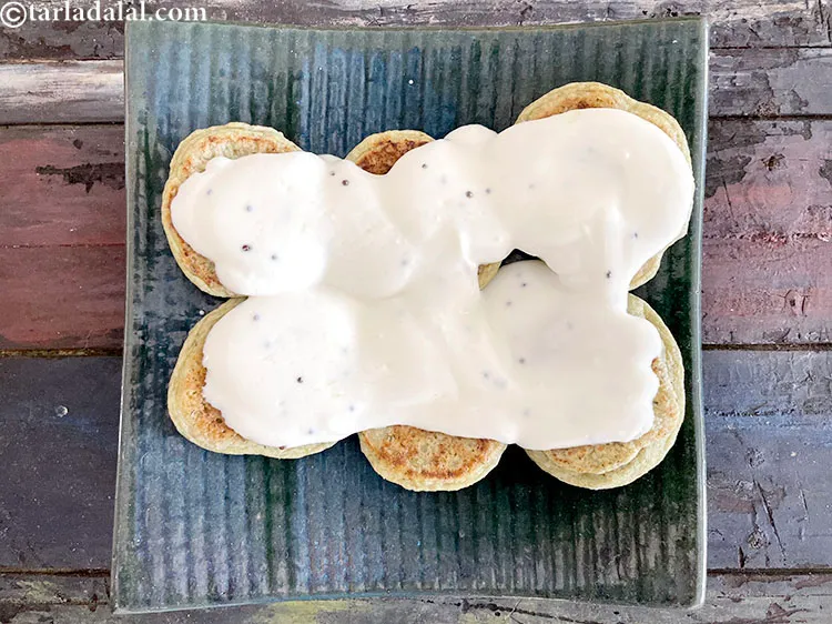Step 46 – Spread 1 1/2 cups of prepared curd mixture&nbsp;evenly the over vadas.