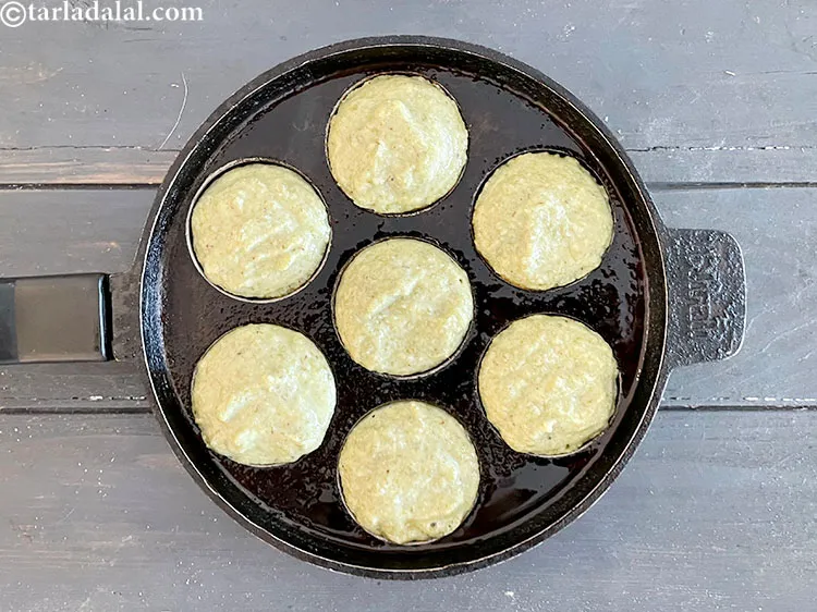 Step 54 – Take the batter of moong dal dahi vada and fill the appe mould with it.
