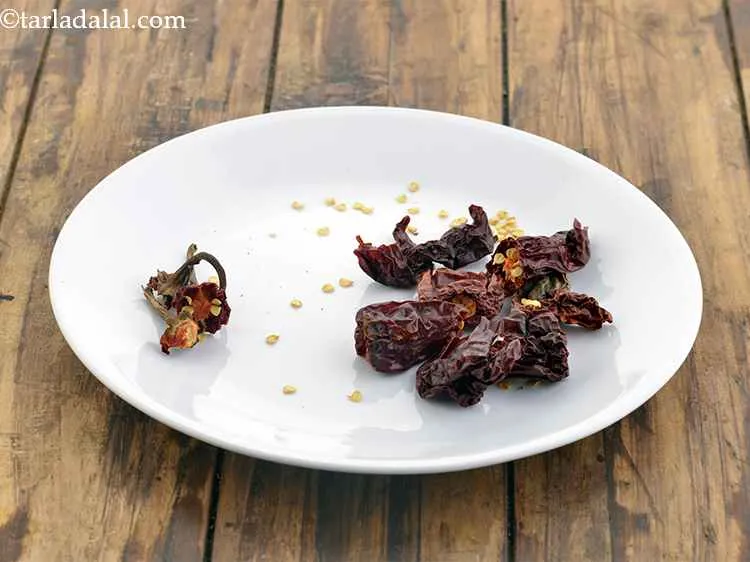 Step 21 – To make the paste for<strong> Mughlai dum aloo, </strong>take the red chillies, remove their stalks …