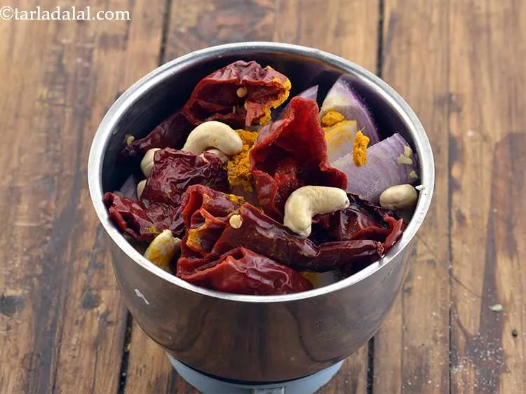 Step 31 – Add the soaked and drained dry red chillies and kaju.