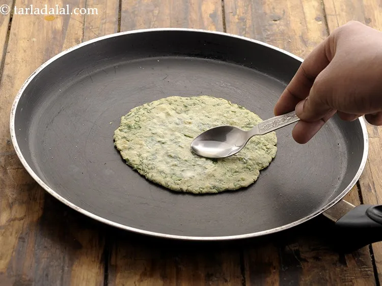 Step 22 – Flip the roti and cook it using &frac12; tsp of oil till golden brown spots …