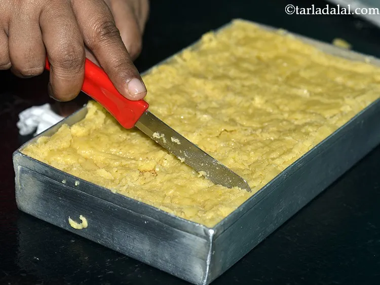 Step 20 – While the mixture is still warm, cut the <strong>Indian Sweet</strong> <strong>Mysore Pak</strong> into pieces of …