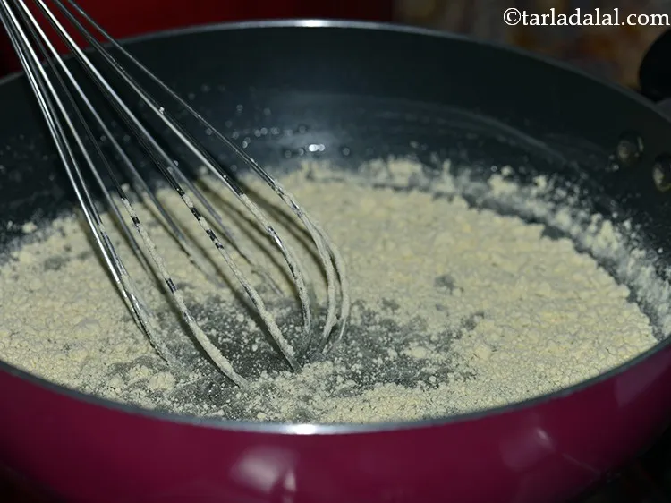 Step 11 – Once the sugar syrup of <strong>Indian sweet mysore pak</strong> reaches the one string consistency, reduce …