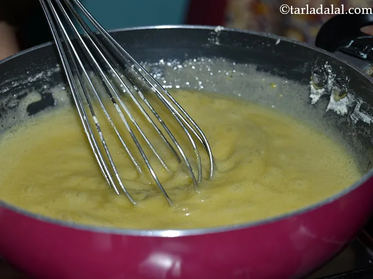 Step 13 – Repeat this procedure of adding besan and whisking 3 more times till all the besan …
