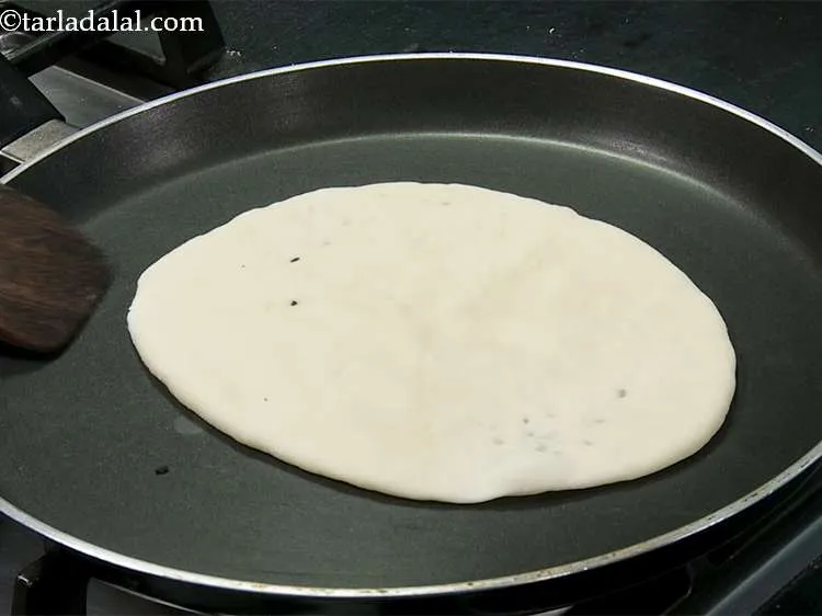 Step 13 – Heat a non-stick tava (griddle) and place the naan over it with the sesame seeds …