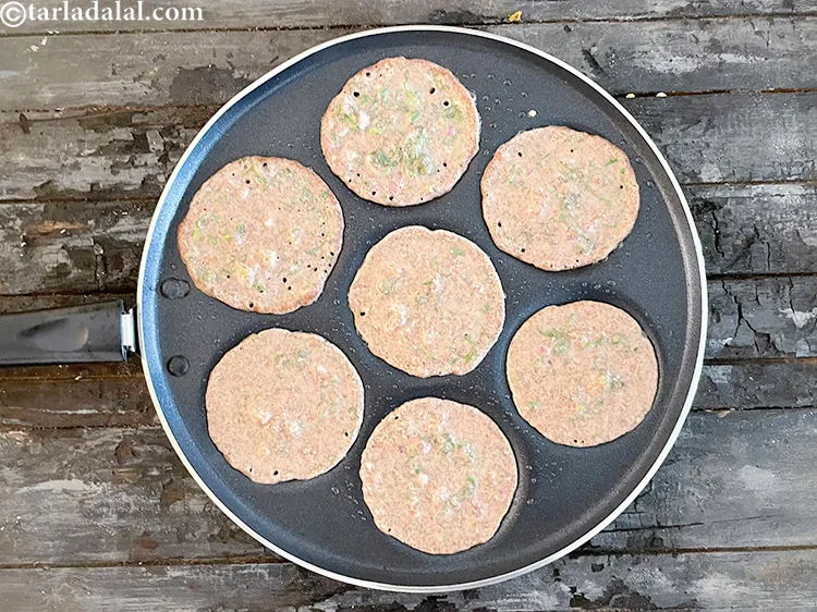 Step 25 – Pour 1 1/2&nbsp;to&nbsp;2 tbsp of the batter in each uttapam mould and spread it lightly.