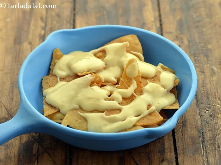 स्टेप 6 – चिप्स के ऊपर पिघला हुआ चीज़ फैलाएं।