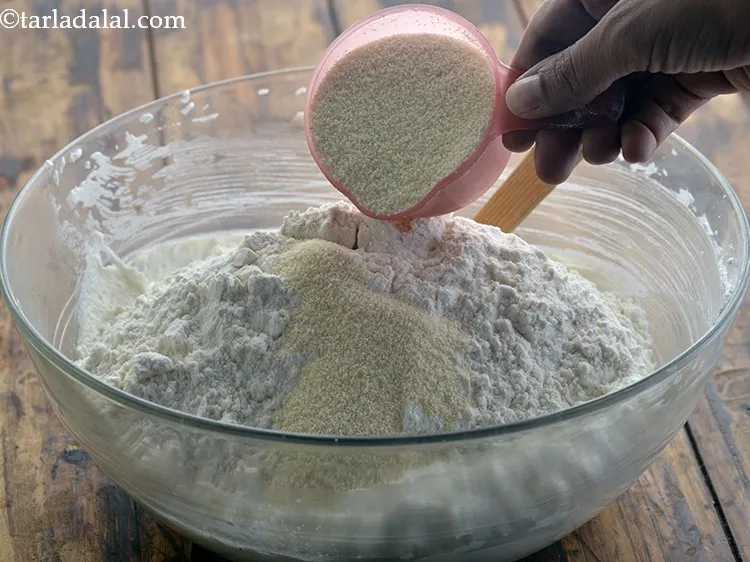 Step 10 – Also, add rava. Semolina provides an added crunch and nice texture to the baked <strong>nankhatai</strong>.