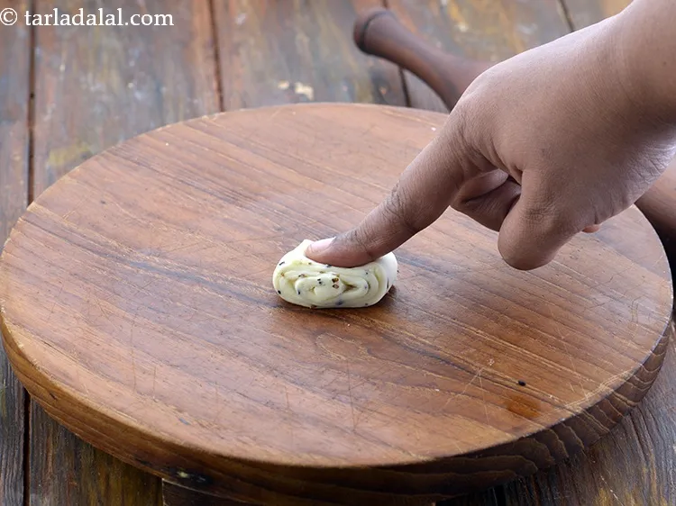 Step 26 – Place a portion on a rolling board, where the swirled part in facing sideways and …