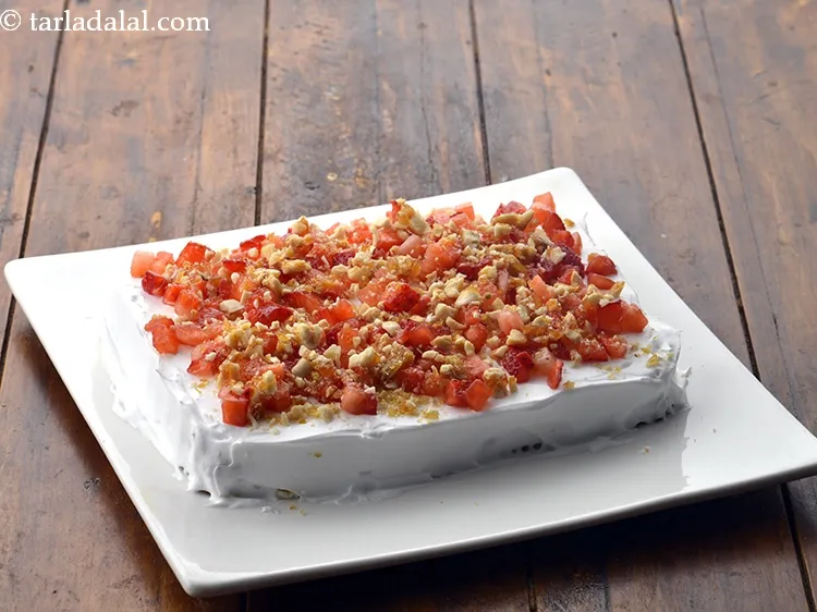 Step 18 – Also sprinkle 2 tbsp of coarsely&nbsp;<a href="https://www.tarladalal.com/glossary-crushed-mixed-nut-chikki--2284i">crushed mixed nut chikki</a> evenly over it.