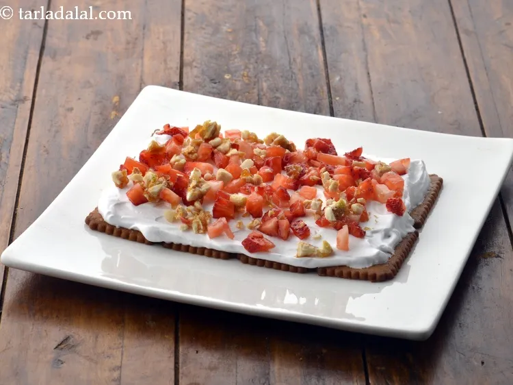 Step 13 – Sprinkle 1 tbsp of coarsely&nbsp;<a href="https://www.tarladalal.com/glossary-crushed-mixed-nut-chikki--2284i">crushed mixed nut chikki</a>&nbsp;evenly over it.