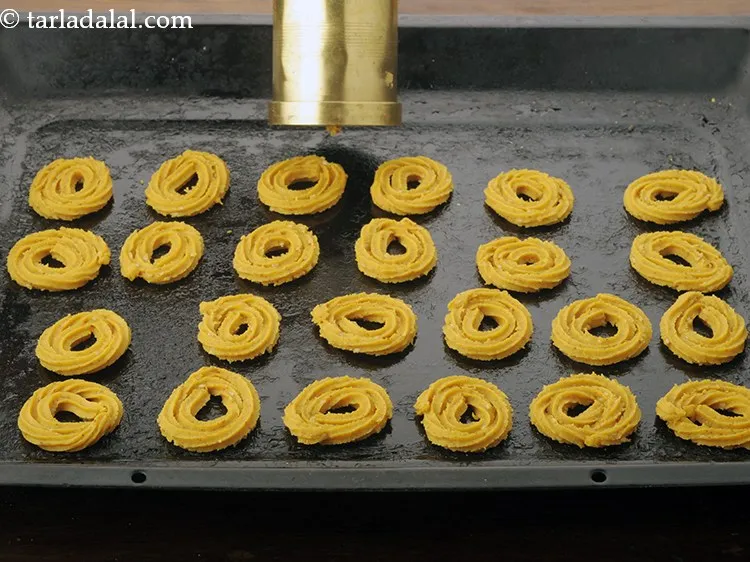 Step 16 – Press out round swirls of the dough onto a greased baking tray, working closely from …