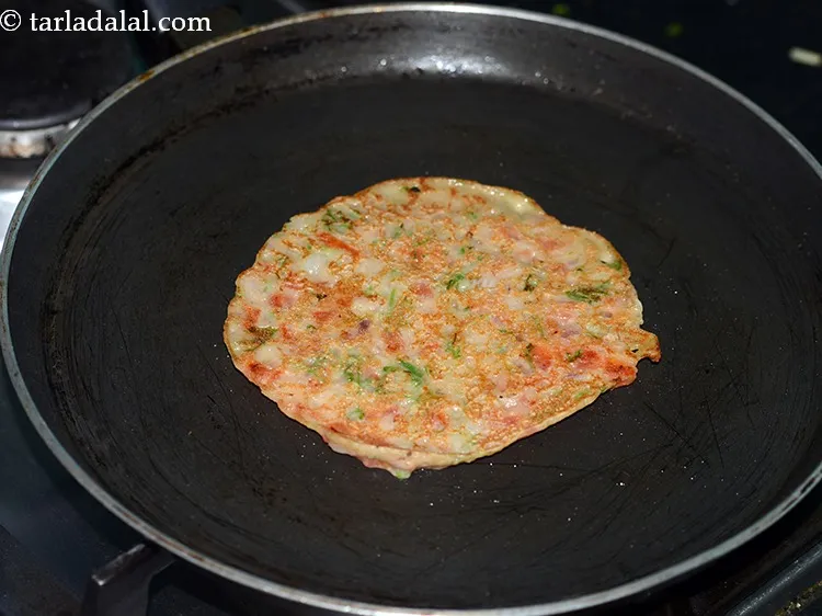 स्टेप 15 – <strong>न्यूट्रिशियस ज्वार टमाटर चीला </strong>को पलटें और पकाएँ जब तक …