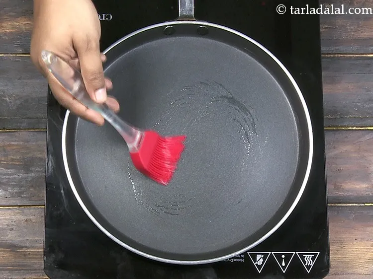 Step 32 – Grease it with &frac14; tsp of <a href="https://www.tarladalal.com/glossary-oil-671i">oil</a>.