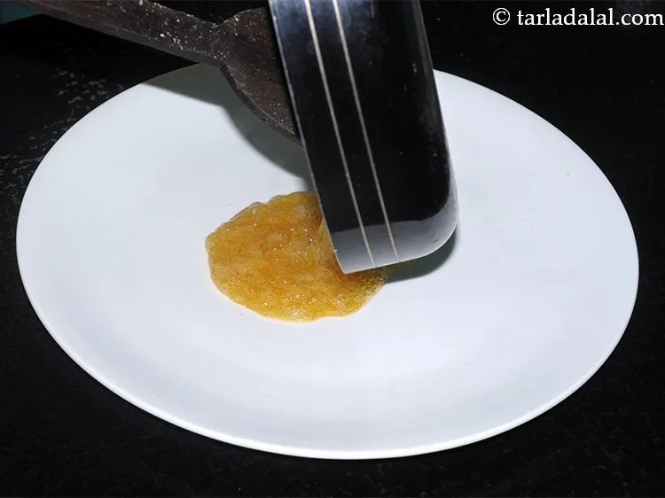 Step 18 – Transfer the jaggery mixture into a flat thali and allow it to cool slightly.