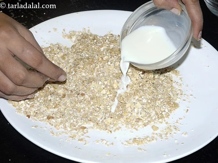 Step 24 – Add little milk. This will help in binding the Oats dry fruits ladoo.